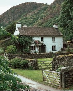 a white house sitting on top of a lush green hillside