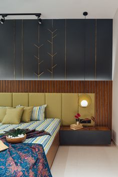 a bed room with a neatly made bed next to a night stand and lamps on the wall