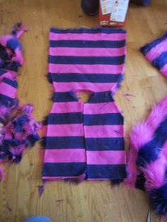 purple and black striped clothing sitting on top of a wooden floor