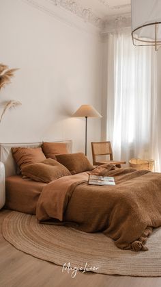 a bedroom with a bed, chair and lamp on the floor in front of a window