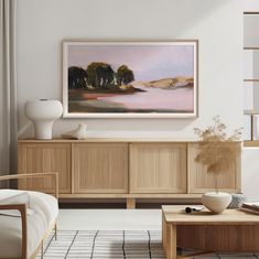 a living room scene with focus on the coffee table and painting hanging over the entertainment center