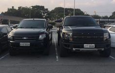 two black trucks parked in a parking lot