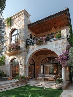 a large stone house with lots of windows and flowers on the balconies above it