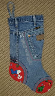 a pair of blue jeans with red and green patches on them, sitting on the floor