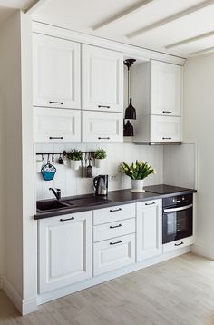 a kitchen with white cabinets and black counter tops is pictured in this image from the front view