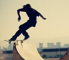 a man riding a skateboard up the side of a wooden ramp at a skate park