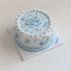 a blue and white birthday cake sitting on top of a table