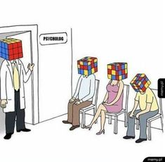 three people are sitting in chairs with cubes on their heads, and one man is standing