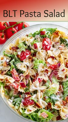 a bowl filled with pasta salad next to tomatoes and lettuce on the side