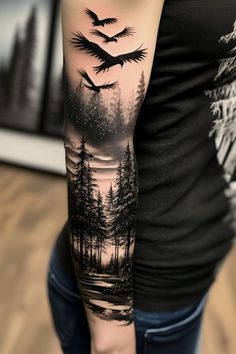 a woman's arm with a black and white landscape tattoo on the left sleeve