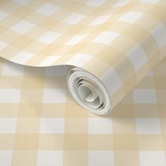 a yellow and white checkered wallpaper with a rolled up roll on the floor