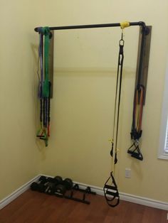 there is a wall mounted gym equipment in the corner of this room with hard wood flooring