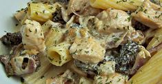 a pasta dish with chicken, mushrooms and other things in it on a white plate