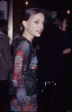 a woman standing next to a bike wearing a dress with circles on it's sleeves