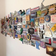 a metal wall with many different types of magnets and pictures on it, hanging from the side of a white wall