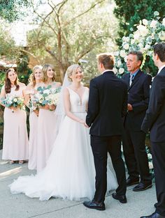 a group of people standing next to each other in front of a man and woman