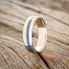 a wedding ring with blue and white wood inlays on the outside of it