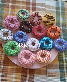 there are many donuts on the plate and one is made out of knitted yarn