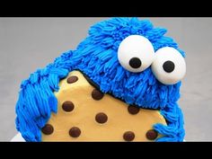 a cookie monster cake is decorated with blue icing and chocolate dots on it's face