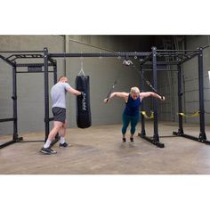 two people in a gym doing exercises with punching gloves on the wall behind them,