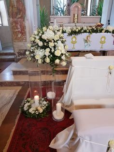 flowers and candles sit on the floor in front of a casket