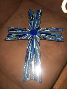 a cross made out of glass sitting on top of a couch