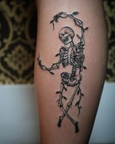 a skeleton tattoo on the leg of a person with an arrow in it's hand