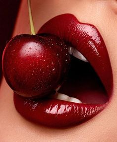 a woman's lips with red lipstick and an apple