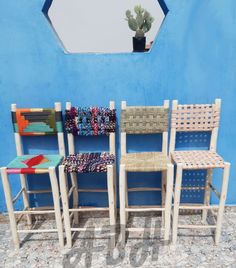 four chairs are lined up in front of a blue wall with a potted cactus