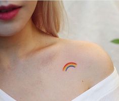 a woman with a rainbow tattoo on her left shoulder and right arm behind her chest