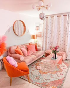 the living room is decorated in pink and orange colors with pops of color on the furniture