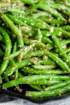 green beans with garlic and seasoning in a black bowl on a tablecloth cloth