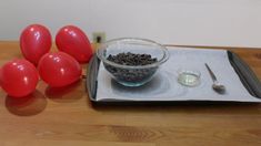 red balloons and chocolate chips in a bowl on a tray with napkins next to them