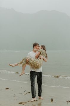 a man carrying a woman on the beach