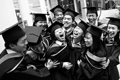 a group of people in graduation caps and gowns posing for a photo with each other