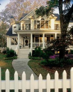 a house with white picket fence and trees