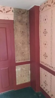 the corner of a room with red walls and peeling paint on the wall behind it