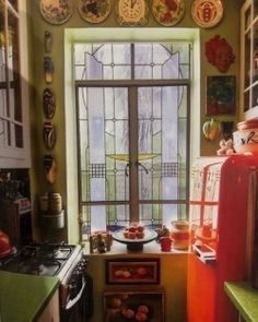 a kitchen filled with lots of different types of dishes on the wall and window sill