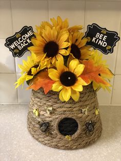 sunflowers in a basket with bee kind stickers on the top and welcome back