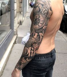 a man with a clock tattoo on his arm is standing in front of a building