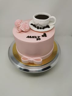 there is a pink cake with coffee and roses on it