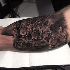 a man's arm with three lions on it and water in the middle, as well as his reflection