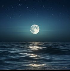 the moon is shining over the ocean at night with stars in the sky above it