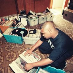 a man sitting on the floor surrounded by records