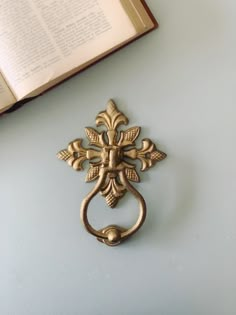 a book is laying on the table next to an antique doorknob