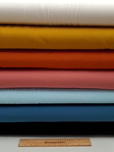 a stack of different colored sheets sitting next to each other on top of a table