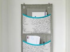 a metal wall hanging organizer with two pockets for pens, paper and other office supplies