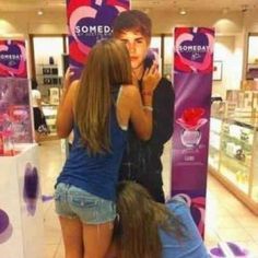 three girls are huddled together in front of some signs