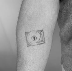 a black and white photo of a man's arm with a cd on it