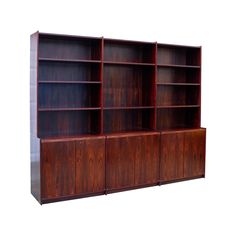 a wooden bookcase with three doors and two shelves on each side, against a white background